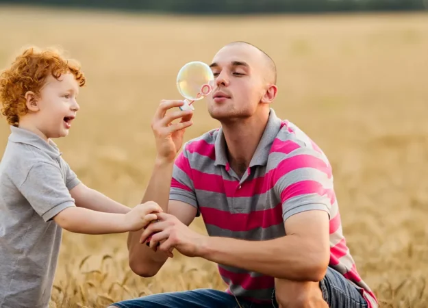 man and child blowing bubbles