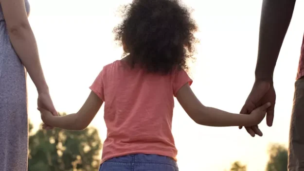 foster child holding parents hands