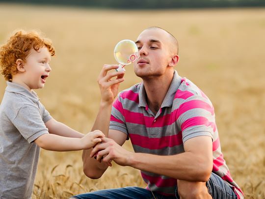 man and child blowing bubbles